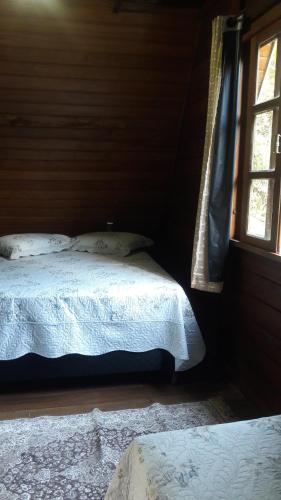 a bedroom with two beds and a window at Sitio Santa Lucia in Santa Teresa