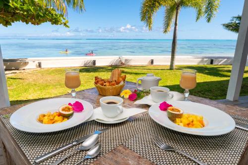 a table topped with plates of food and drinks at Moorea Beach Lodge in Moorea