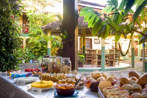 a table with food on it in front of a building at Hospedagem La Bilbaina in Porto Seguro