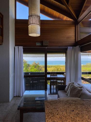 a living room with a couch and a view of the ocean at Morada Prainha in Garopaba