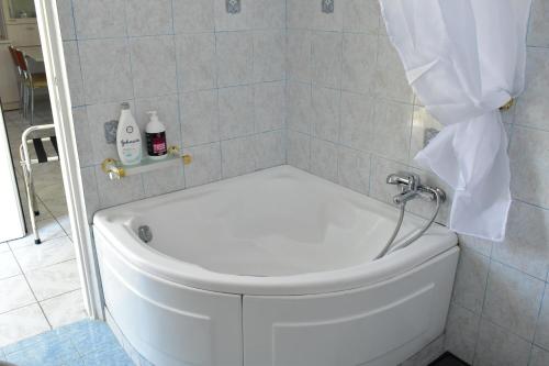 a white bath tub in a bathroom with a window at White Clam Vintage House with sea view & garden in Makrýgialos