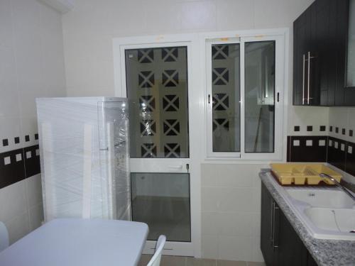 a kitchen with a glass cabinet and a sink at Appartement LaVie in Tunis