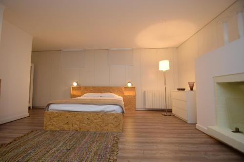 a large bedroom with a bed and a fireplace at GuimaraesLiving - Hostel & Adventure in Guimarães