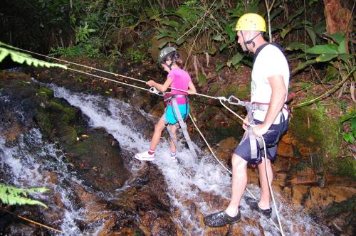 a man and woman crossing a rope bridge over a waterfall at Plaza Caldas da Imperatriz Resort & Spa in Santo Amaro da Imperatriz