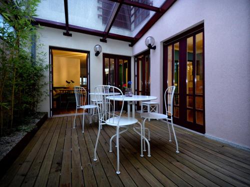 a patio with a table and chairs on a deck at GuimaraesLiving - Hostel & Adventure in Guimarães