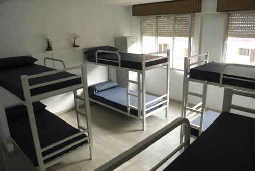 a dorm room with three bunk beds in it at Albergue Trabazo in Silleda