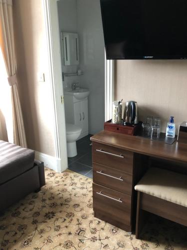 a hotel room with a desk and a bathroom at Braehead Guest House in Inverness