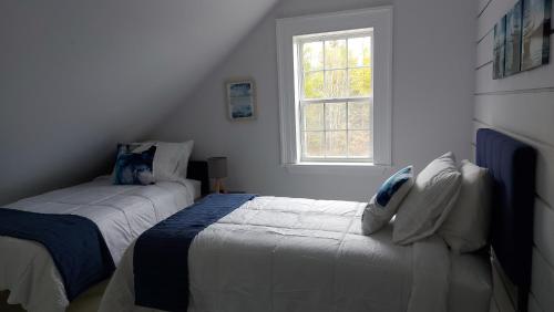 a bedroom with two beds and a window at Cozy Harbour House in Isaacs Harbour