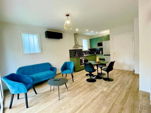 ein Wohnzimmer mit einem blauen Sofa und Stühlen in der Unterkunft Villa Elisa M in Aubenas