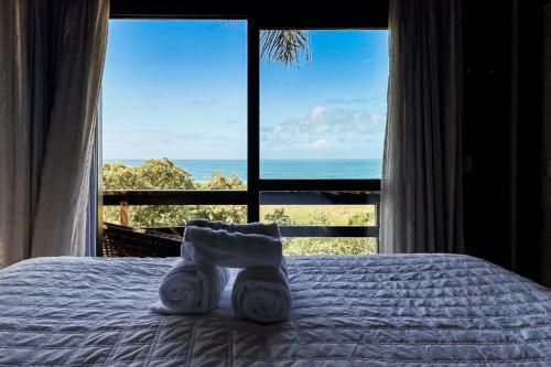 a bedroom with a bed with a view of the ocean at Morada Prainha in Garopaba