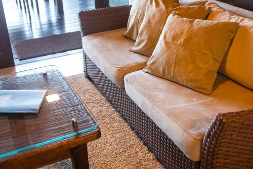 a couch with pillows sitting next to a coffee table at Morada Prainha in Garopaba