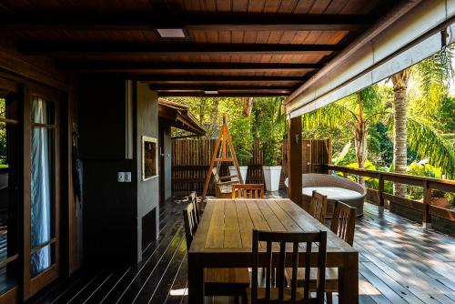 a wooden deck with a table and chairs on it at Morada Prainha in Garopaba