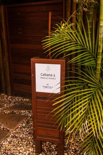 a sign sitting in front of a plant at Morada Prainha in Garopaba