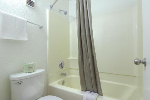 a white bathroom with a toilet and a shower at Studio 6 Suites Las Vegas, NV - Tropicana in Las Vegas