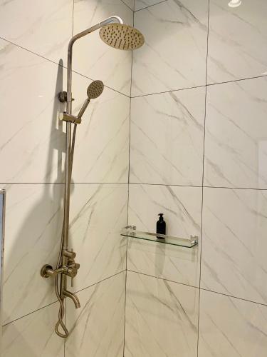 a shower with a shower head in a bathroom at Badolina Bungalows in Nungwi