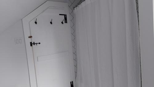 a hallway with a white door and a white curtain at Cozy Harbour House in Isaacs Harbour