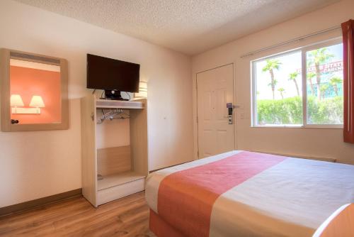 1 dormitorio con 1 cama, TV y ventana en Motel 6-Las Vegas, NV - Boulder Hwy, en Las Vegas