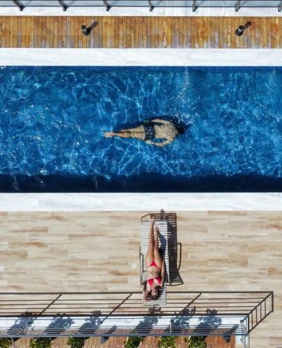 a woman sitting on a chair in front of a painting at Buenos Ayres Flats, Cabo Branco 1qto cozinha completa in João Pessoa
