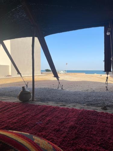 a view of the beach from a tent with a rug at Paradisiac and luxurious villa with private beach in Dakhla in Dakhla
