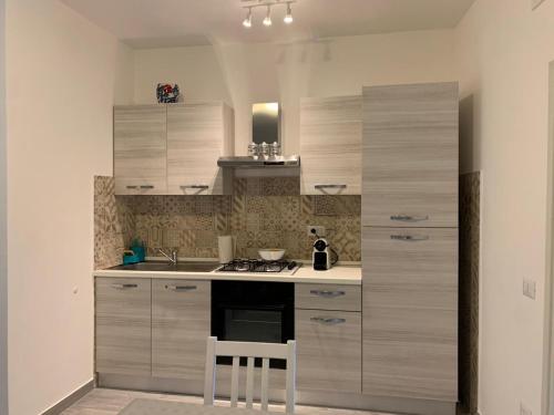 uma cozinha com armários de madeira e um forno com placa de fogão em Il Nido delle Rondini em Formia
