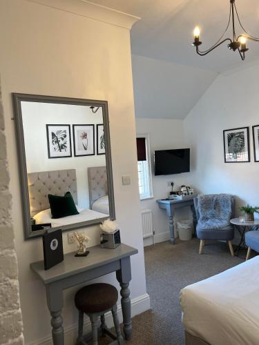 a bedroom with a mirror and a bed and a desk at Castle Hotel in Eynsford