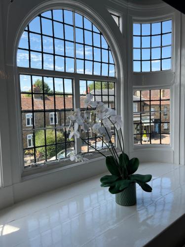 a vase of flowers on a counter in front of a window at Castle Hotel in Eynsford