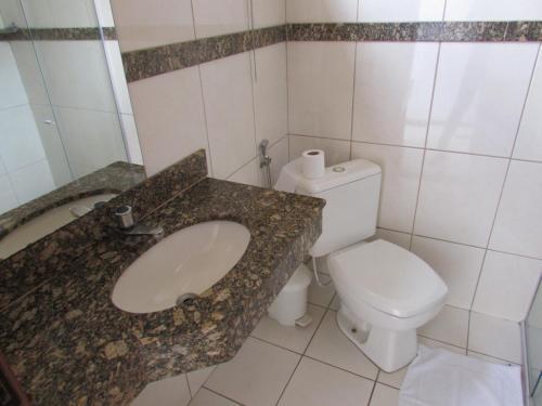 y baño con lavabo y aseo. en Hotel Oitis, en Governador Valadares