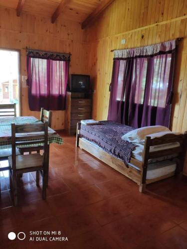 a bedroom with two beds and a table and a tv at Complejo Don Raúl in Puerto Rico