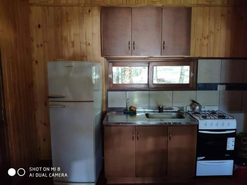 a kitchen with a white refrigerator and wooden cabinets at Complejo Don Raúl in Puerto Rico