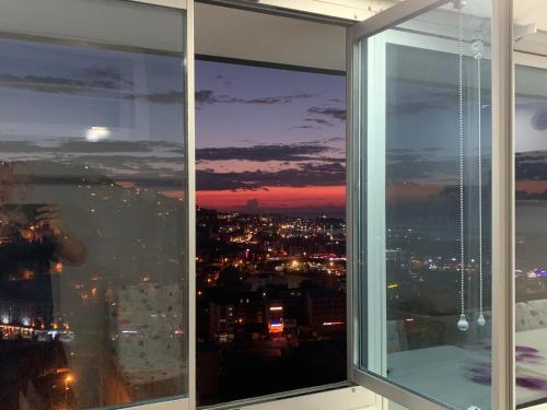 a window with a view of a city at night at NURALP APART OTEL - Trabzon in Trabzon