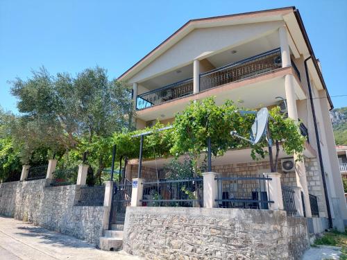 a large house with a stone wall and trees at Darija in Herceg-Novi