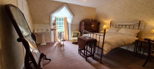 a bedroom with a bed, chair and a mirror at Thrumster House in Wick