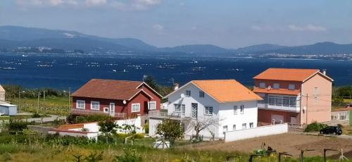 a group of houses on a hill next to the water at Casa Ania in Villanueva de Arosa