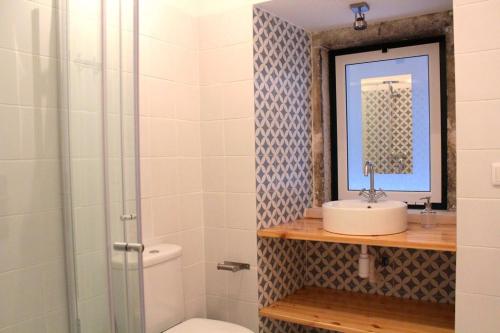 uma casa de banho com um WC, um lavatório e um espelho. em Lisbon Coral Apartment em Lisboa