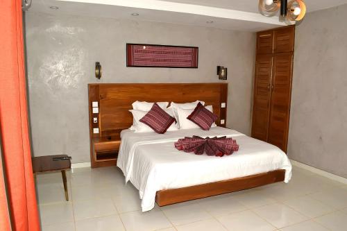 a bedroom with a bed with a bow on it at Les Flamboyants in Saly Portudal