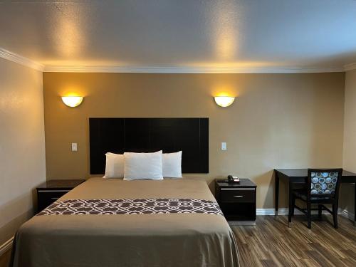 a hotel room with a bed and a desk at Walnut Inn & Suites West Covina in West Covina