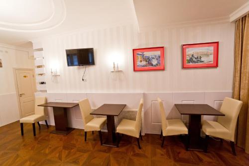 a dining room with two tables and chairs at Aruna Hotel in Astana