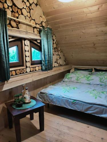 1 dormitorio con 1 cama y 1 mesa en una cabaña en Pod Milanem en Przemyśl