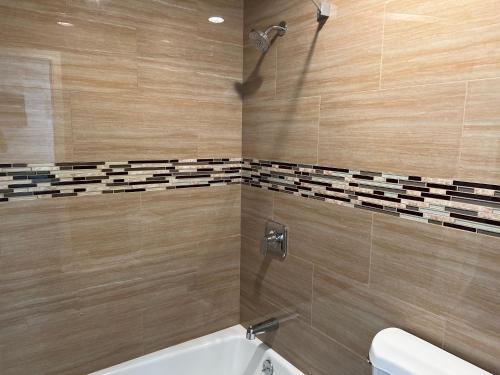 a bathroom with a tub and a toilet and a sink at Walnut Inn & Suites West Covina in West Covina
