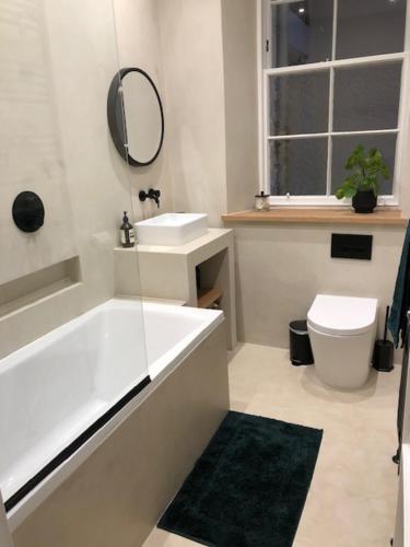a bathroom with a tub and a sink and a mirror at Lovely 3 bedroom family friendly cottage in North Berwick in North Berwick