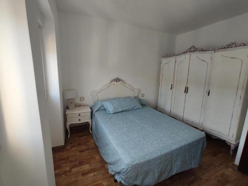 1 dormitorio con 1 cama y armario blanco en Agradable casa con patio, en Salamanca