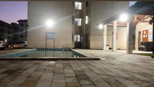 - une piscine en face d'un bâtiment la nuit dans l'établissement Flat Home Practice, à São Luís