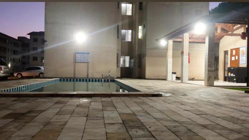 a swimming pool in front of a building at night at Flat Home Practice in São Luís