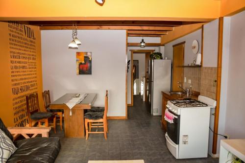 Il comprend une cuisine et un salon avec une cuisinière et une table. dans l'établissement Espacio Pueblo, à San Carlos de Bariloche