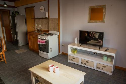 Il comprend un salon avec une cuisine équipée d'une cuisinière et une télévision. dans l'établissement Espacio Pueblo, à San Carlos de Bariloche