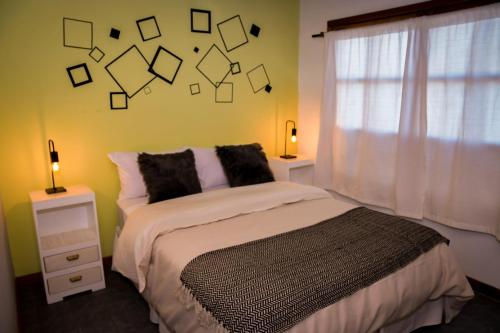- une chambre avec un lit et une fenêtre avec des carrés sur le mur dans l'établissement Espacio Pueblo, à San Carlos de Bariloche