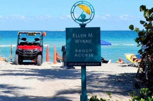 a sign on the beach with a beach access at Sunny Isles Ocean Reserve Condo Apartments in Miami Beach
