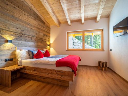 a bedroom with a bed with a wooden wall at Chalet Georg in Zellberg