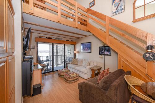 a living room with a couch and a staircase at 706H Studio Loft One Bath in Oakland