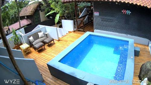 ein großer Pool auf einer Holzterrasse mit einem Haus in der Unterkunft Quinta Esencia in Brasilito